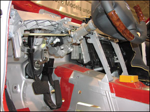 The S-Class Mercedes-Benz steering column&rsquo;s swivel linkage is shown just above floorboard level. It is evident that any pulling effort applied to the upper section of this split column will raise only this portion of the column. Note the telescoping feature of the steering column is also visible near the base of the steering wheel.