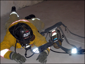 Photo 7: To completely remove the S.C.B.A. the firefighter should loosen the shoulder straps and remove the waist harness. They should then 'roll' out of the S.C.B.A. by rolling over to the left.
