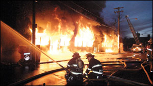 Cohoes Firefighters Joe Pailley and Jim Darwak operate a monitor at the front of the bakery. Cohoes companies were on the scene for 23 hours.