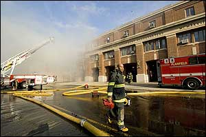 A firefighter walks in front a burning mattress supply building in Plainfield, N.J., Dec. 12.