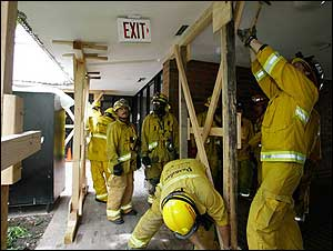 Pasadena firefighters work to secure a two-story building after a balcony collapsed, April 5.