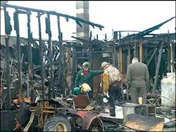 Dick Phillips, owner of of Vermont Field Sports, center, examines the remains of his Middlebury sporting goods store. Dick Phillips, owner of of Vermont Field Sports, center, examines the remains of his Middlebury sporting goods store.