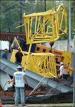 Crews remove a fallen crane from the site after it collapsed Monday. Crews remove a fallen crane from the site after it collapsed Monday.