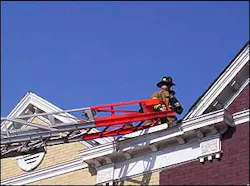 A firefighter from the station stands on the roof of a rowhouse where a small fire occured in the morning. A firefighter from the station stands on the roof of a rowhouse where a small fire occured in the morning.