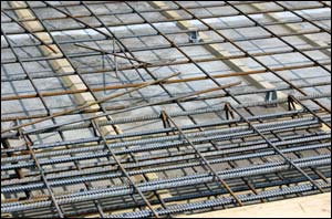 Steel is a common product used to reinforce concrete and this 'rebar' is put in place prior to the concrete being poured.