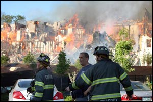 Flames consumed the roof of the four-story building Thursday and the thick black smoke that poured from the fire could be seen from Boston, about 12 miles south.