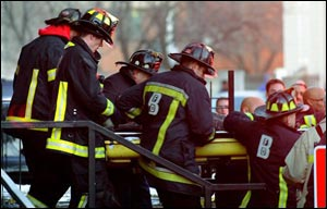 Firefighters remove the body of Lt. Kevin Kelly following the tragic crash.