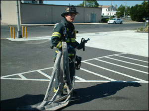 Figure 2 - Here, the nozzle firefighter has the nozzle and 50 feet of hose that he will bring to the drop point. The nozzle firefighter drops the 50 feet in an area that is relatively close to the fire's location, but not so close that the team is in an IDLH environment. The drop point uses compartmentation, elevation, or exterior advantages to stretch the line dry. This allows for a much quicker stretch but without placing the members in danger. The drop point also should offer enough room to flake out the line so as to prevent kinks.