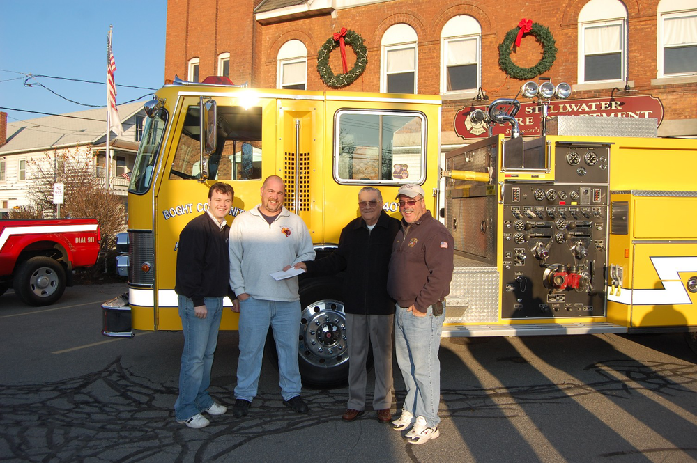 (From left to right)Stillwater Fire Chief Shane Mahar, Boght Assistant Chief Scott St. Denis, Village of Stillwater Mayor Ernest Martin (handing over the check), and Stillwater Assistant Chief Jeff Mahar.