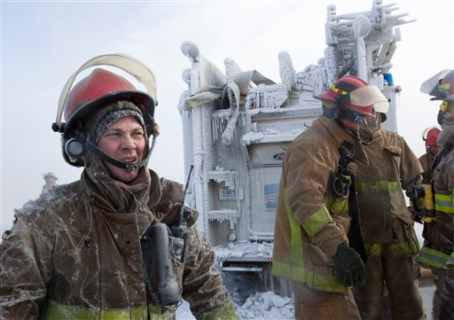 Firefighters and their engine are covered with ice as they battle a fire at a bowling alley in the Omaha, Neb., suburb of Elkhorn on Jan. 7.