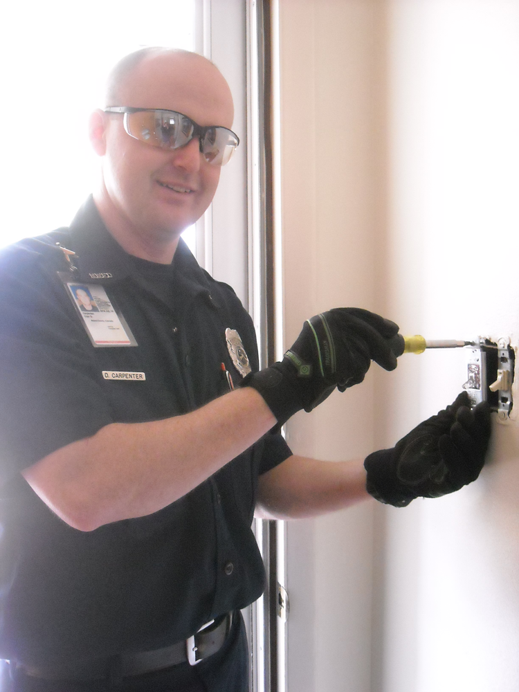 Firefighter/electrician, David Carpenter installs a GE Emergency Light Switch in a resident's home free of charge.