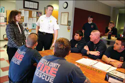 Joanne Turner (standing, left) and Osceola County Fire Rescue Chief Richard Collins (standing right) talk with a crew at one of the Osceola County fire stations. Joanne Turner (standing, left) and Osceola County Fire Rescue Chief Richard Collins (standing right) talk with a crew at one of the Osceola County fire stations.