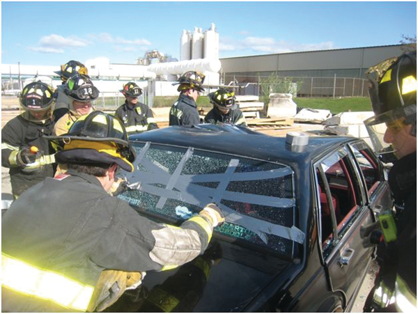 Photo 1. Rescuers use duct tape to provide some cohesion to the tempered glass so it can be removed collectively.