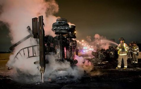 Fort Worth Firefighters Rick McKinney and Frank Becerra extinguish the burning remains of a tanker truck involved in an early morning wreck on I30 near Beach St.