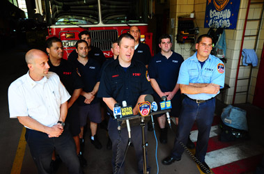 Firefighter Sean Connolly describes the rescue with Chief Joseph Omeste, left, and Lt. Edward Gonzalez, right.