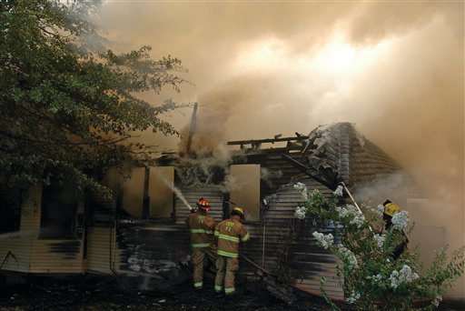 Firefighters work a house fire on Elm Street in Troy, Ala.