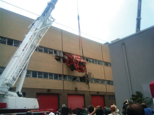 A New York Department of Sanitation salt-spreading truck crashed through a wall on the second floor of a repair shop in the Queens borough of New York.