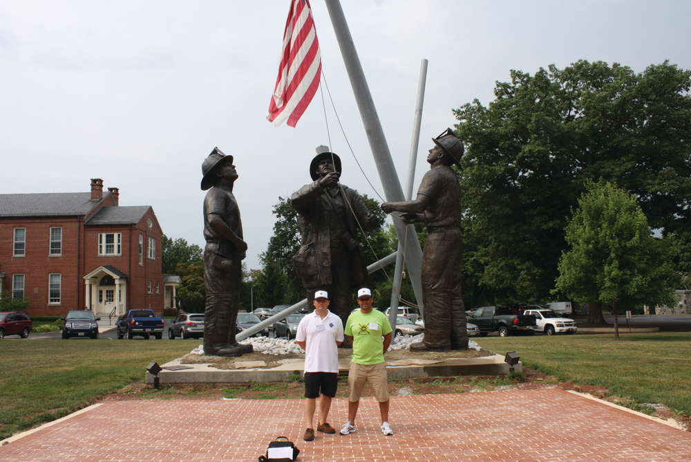 Australian firefighters Shane Austin, left, and Ben Chalmers, right, pose in front of a statue honoring those who died on 9/11 at the National Fire Academy.