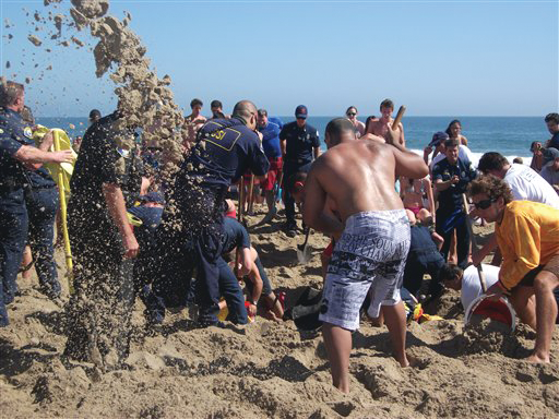 Rescuers dig out Matt Mina, 17, who was buried underneath six feet of sand in Newport Beach, Calif.