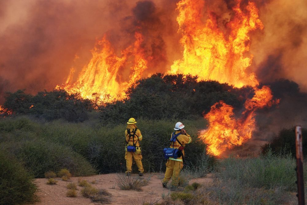 CAJON PASS, CA, SEPT. 2, 2011 &ndash; A vegetation fire started in the center divider of Interstate 15, the main highway for travelers between Southern California and Las Vegas, NV, the Colorado River and other destinations. The fire started about 1&frac12; miles from the top of the Cajon Pass, jumped the southbound lanes and was burning up hills and into the high-desert community of Oak Hill just west of Hesperia. The fire, fed by fuels that had not burned in a long time, roared into and around expensive homes and only the hard work by crews from the San Bernardino County Fire Department, the U.S. Forest Service and dozens of engines from various cites kept the fire away from homes, although two of them were badly damaged and numerous animals were lost at one ranch. Hundreds of firefighters supported by helicopters and air tankers, including the huge DC-10, fought for six hours before nightfall lowered the temperature and wind. The fire was fully contained three days later. Two firefighters were taken to a hospital. At the height of the fire, the California Highway Patrol shut down the entire interstate for hours, stranding thousands of travelers.