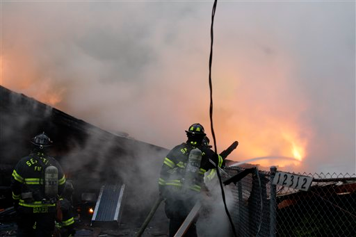 Seattle firefighters work to extinguish a fire at a home in Seattle following a large explosion.