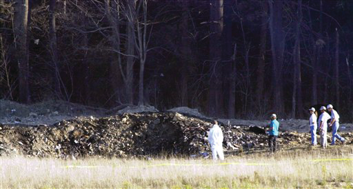 In this Tuesday, Sept. 11, 2001 file photo, emergency workers look at the crater created when United Airlines Flight 93 crashed near Shanksville, Pa.