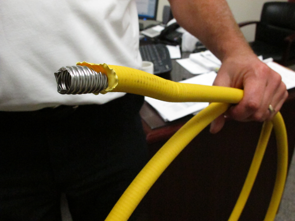 Genoa Township Fire Chief Gary Honeycutt holds corrugated stainless steel tubing, or CSST, at his office near Westerville, Ohio.