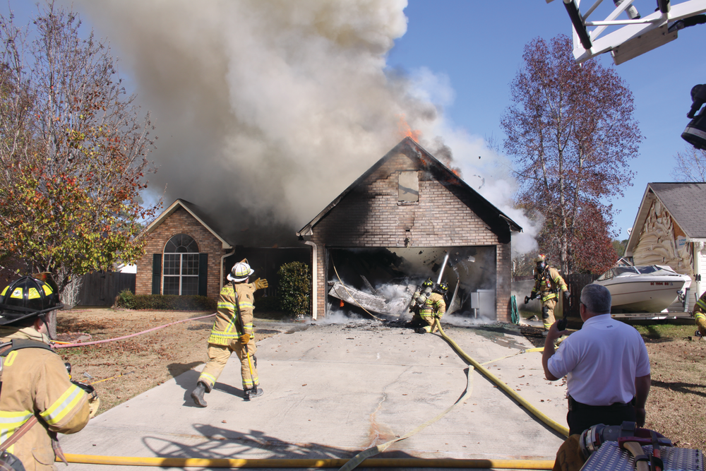 When the garage door collapsed, Assistant Chief Norman Cutshall requested the nozzle team to back up. Photos by Steve Skipton
