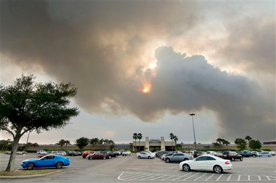 A plume of smoke blots out the sun over the Santa Rosa Mall in Mary Esther, Fla. on May 29.