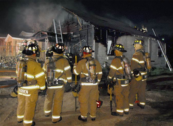 A rapid intervention team stands ready at a house fire in Fort Worth, TX.