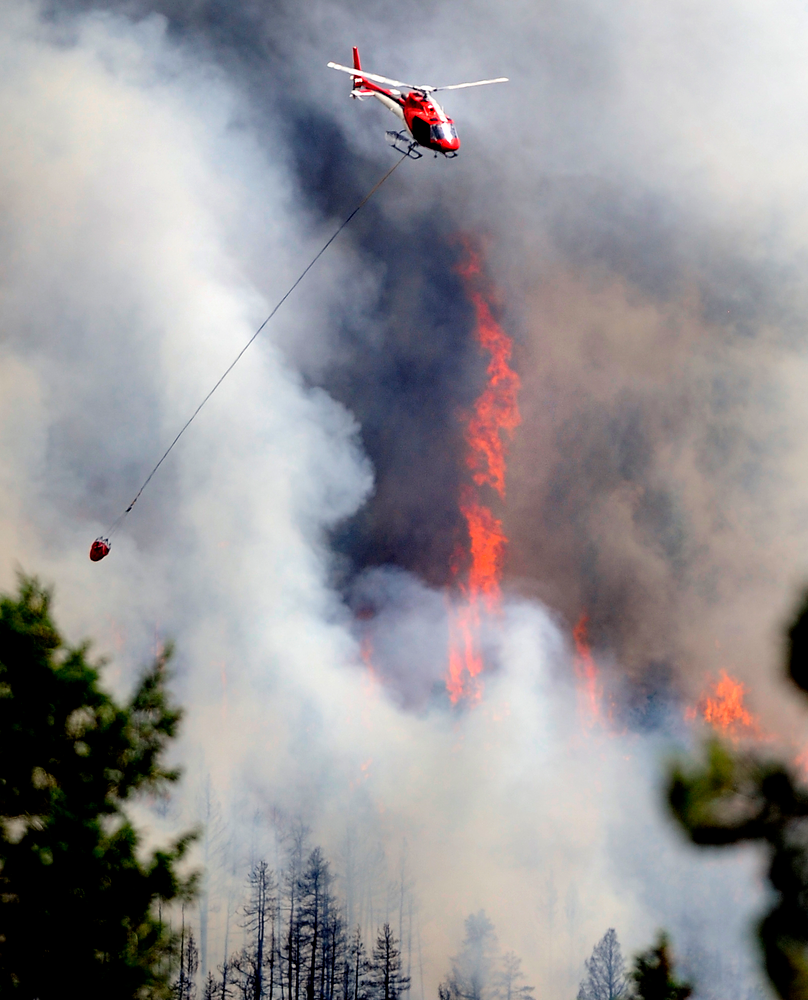 A firefighting helicopter flies above the Flagstaff fire on June 26.