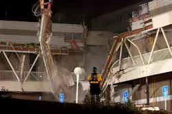 A rescue worker watches as a demolition crane as it tears into part of the Algo Centre Mall, in Elliot Lake, Ontario on June 26. A rescue worker watches as a demolition crane as it tears into part of the Algo Centre Mall, in Elliot Lake, Ontario on June 26.