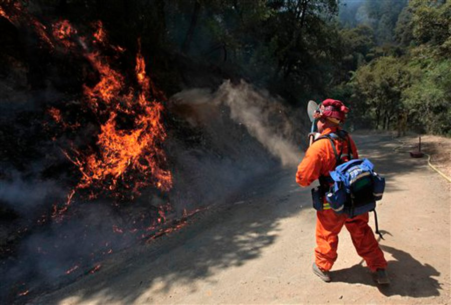 An inmate firefighter from the Eel River Conservation camp throws dirt on flames from the Robbers Fire near Iowa Hill, Calif. on July 12.