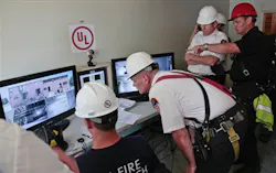 FDNY officials watch live camera feeds from a controlled blaze on Governors Island on July 3. FDNY officials watch live camera feeds from a controlled blaze on Governors Island on July 3.