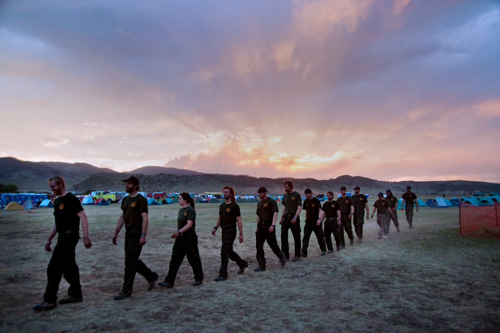 Firefighters from Coeur D'alene, Idaho march to dinner at sunset in the base camp for the High Park wildfire in Fort Collins, Colo. on June 19.