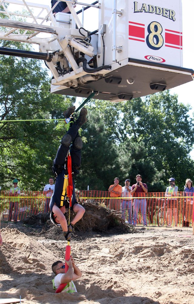 A St. Paul firefighter pulls a construction worker up after he fell down a hole on Aug. 20.