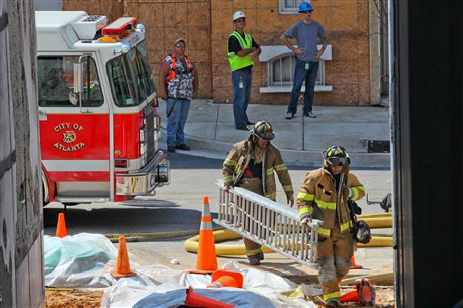 Firefighters move equipment into place near a building at Tyler Perry Studios in Atlanta on Aug. 27.