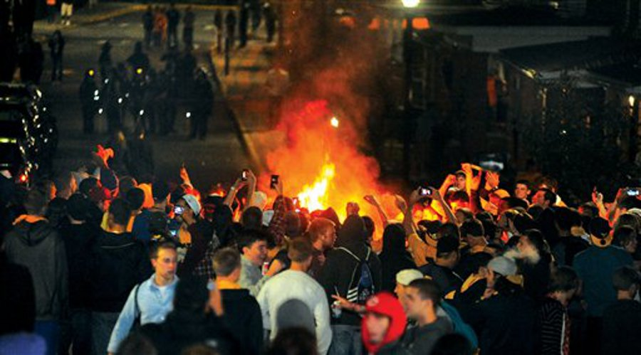 A crowd gathers around a fire set on Grant Avenue after the WVU football team&rsquo;s 48-45 victory over the University of Texas on Oct. 7 in Morgantown, W.Va.