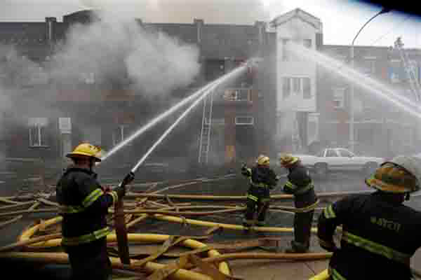 Firefighters battle a of fire Monday, Dec. 10, 2012, in Philadelphia. Fire Department Executive Chief Richard Davison says the blaze broke out Monday afternoon at a three-story industrial garage. Davison says an elderly woman has been taken to the hospital in stable condition. The woman's injuries were not immediately clear.