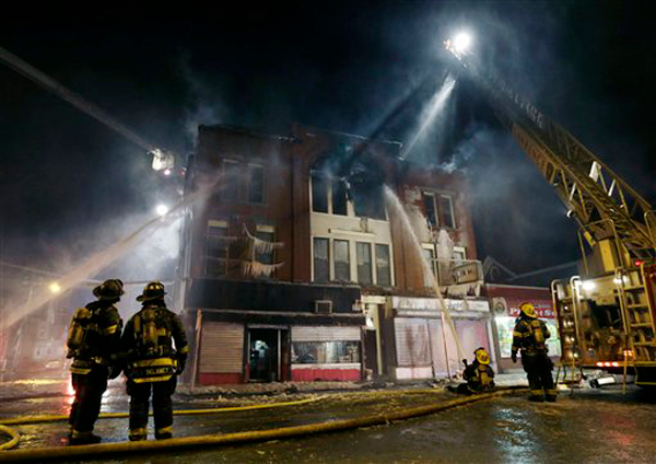 Firefighters work at the scene of a four-alarm fire in a brick business building in Lawrence, Mass. Thursday, Jan. 24, 2013. No injuries were reported according to authorities on the scene. Temperatures dipped into the single digits in the region Thursday.