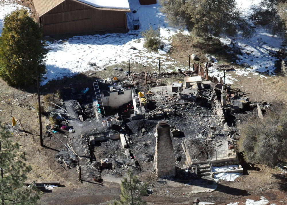 In this aerial photo, law enforcement authorities investigate the charred remains of a cabin Wednesday, Feb. 13, 2013, where quadruple-murder suspect Christopher Dorner is believed to have died after barricading himself inside during a Tuesday stand-off with police in the Angeles Oaks area of Big Bear, Calif. San Bernardino Sheriff's Deputy Jeremiah MacKay was killed and another wounded during the shootout with Dorner.