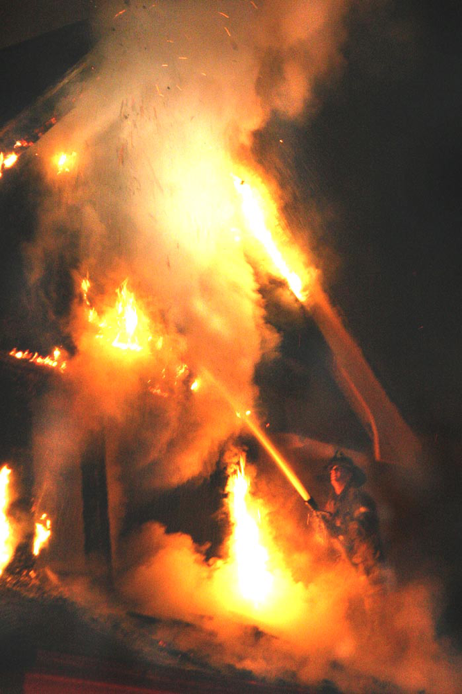A Detroit firefighter works a stream from 1-1/2-inch hoseline at a dwelling fire.