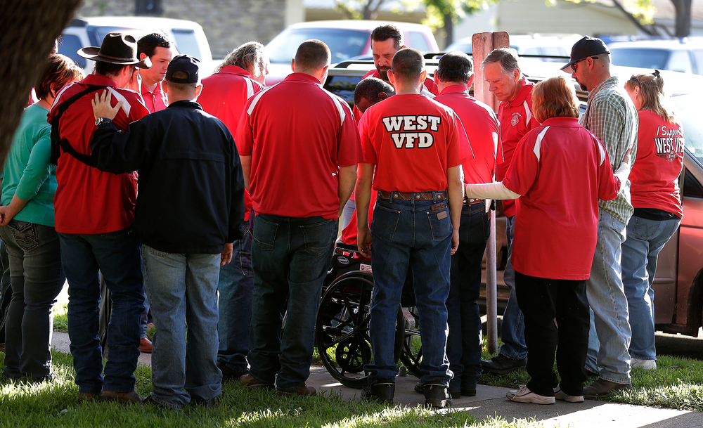 Members of the West Volunteer Fire Department gather after attending a service at St. Mary's Church of the Assumption on Friday.