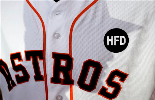 The shadow of Houston Astros' J.D. Martinez is cast on the jersey of Brandon Barnes. The logo honors the fallen firefighters.