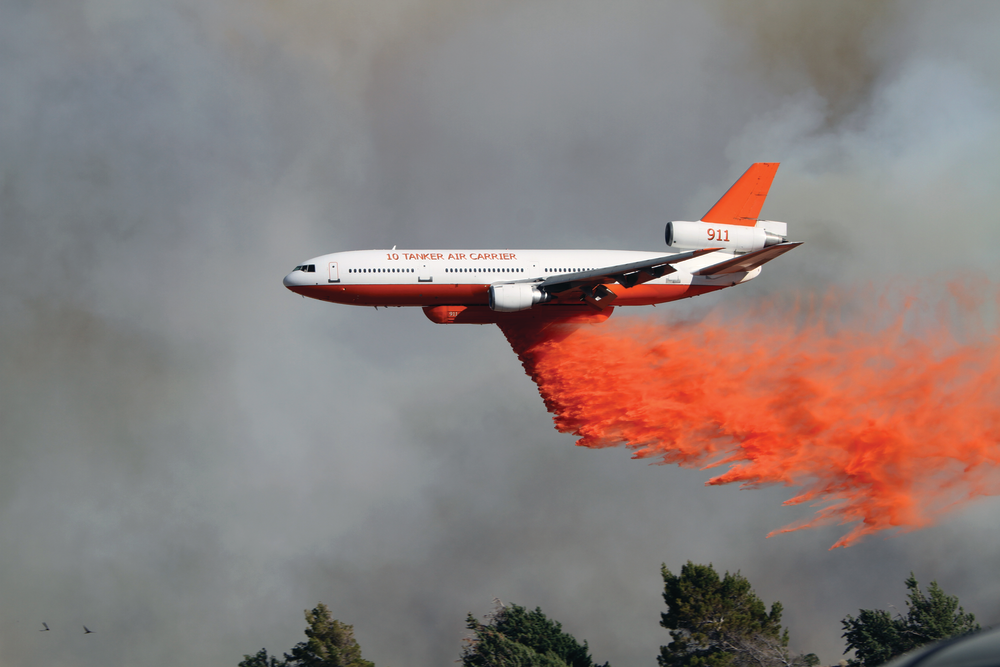On third day of the 'Powerhouse Fire' in Los Angeles County, CA, the fire had spread to 25,000 acres. A DC-10 was called in to drop a line of retardant on the west side of the fire to prevent the fast-moving blaze from entering Kings Canyon, a densely populated and steep canyon area nearby.