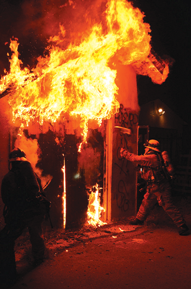 Firefighters work to open up and gain access to the structure.