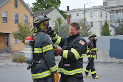 A Portland Fire Department instructor teaches a high school student to properly don self-contained breathing apparatus (SCBA) during the 'Introduction to Firefighting Fundamentals' course. A Portland Fire Department instructor teaches a high school student to properly don self-contained breathing apparatus (SCBA) during the 'Introduction to Firefighting Fundamentals' course.