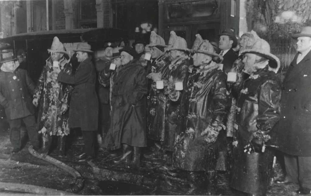 After fighting a five-alarm wallpaper warehouse fire on East 120th Street in Manhattan on the bitterly cold night of Jan. 28, 1926, frozen New York City firefighters take a break with some hot coffee.