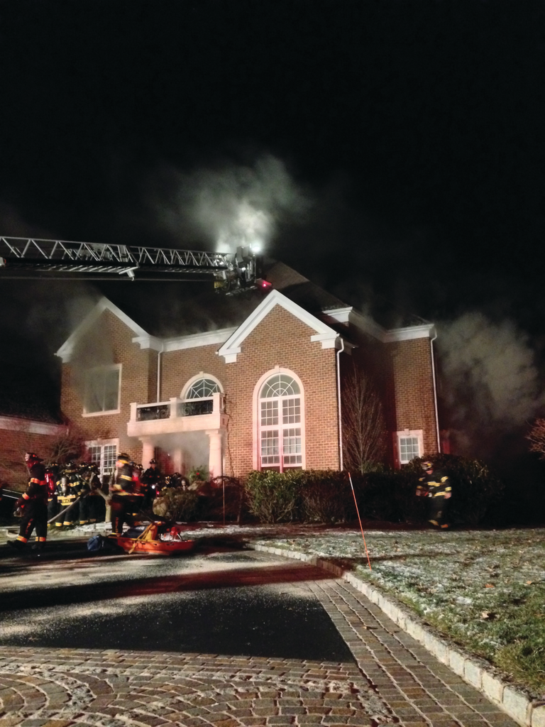 A deputy chief arrived on the scene initially with light smoke visible. This photo shows the house prior to it becoming heavily involved in fire. At this incident, officers and members operating on the scene saw warning signs and took immediate measures to get their members out in time.