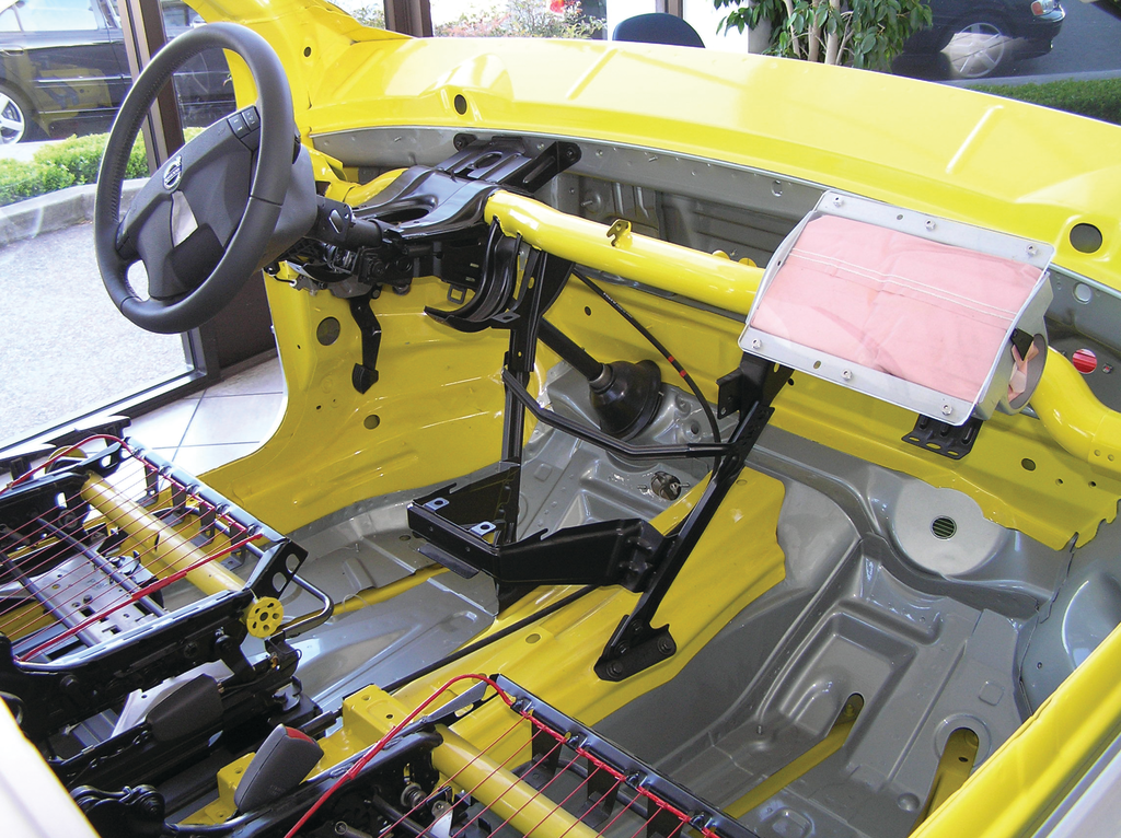 The horizontal dash support pipe (yellow) and the two dash tie downs (black) are shown in this vehicle display. With the instrument panel, dash, and all normal components in place, these items are all hidden from sight.